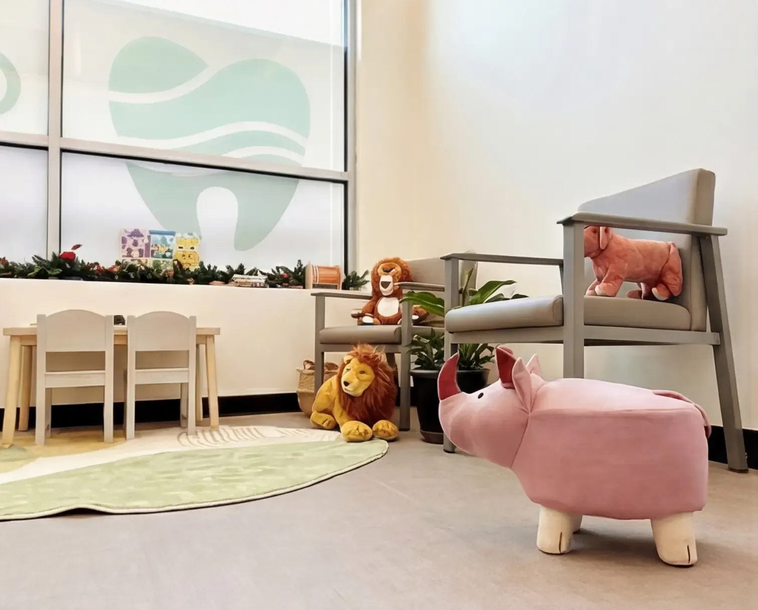 The children's play area at Creekside Dental Langley — a play table, soft toys, and animal seats